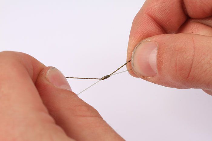 Maak de knopen vochtig en trek aan de diverse stukken lijn om de knopen naar elkaar toe te schuiven.
